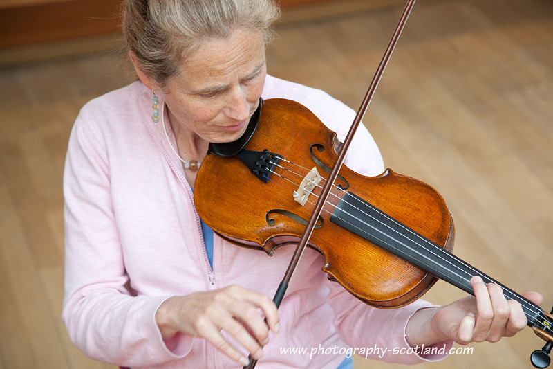 Fiddler bowing a tune in an informal music session Fiddle lessons. and